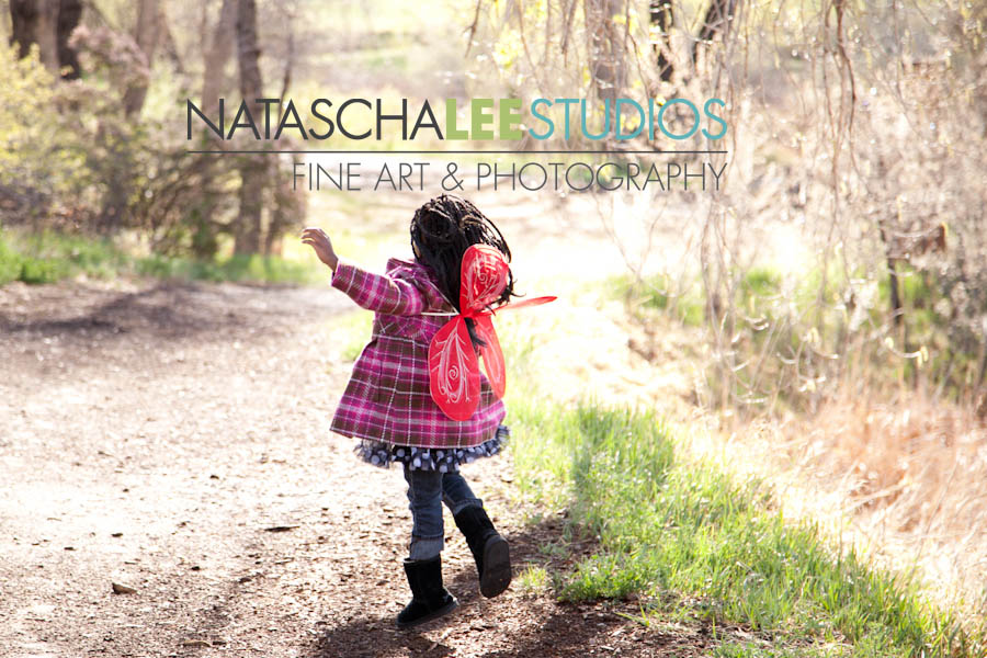 LIttle girl running with butterfy wings by Natascha Lee Studios
